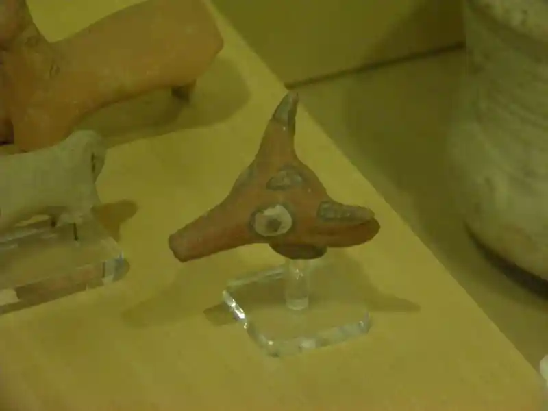 Bull head with a cross on its forehead and squares on its horns made out of clay